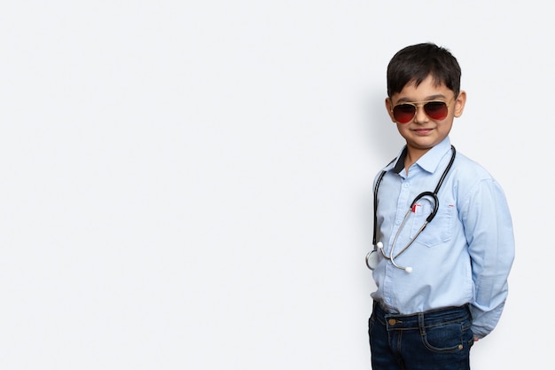 Foto menino sorridente com estetoscópio e óculos de fundo isolado com espaço de cópia
