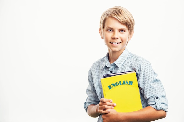 Menino sorridente com livros de inglês parece ansioso para estudar