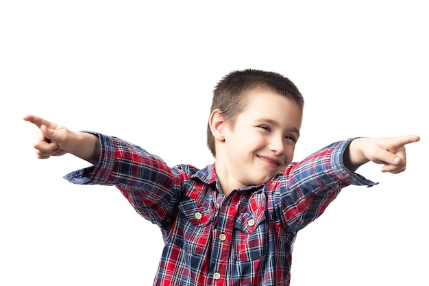 Foto menino sorridente com uma camisa xadrez apontando os dedos sobre um fundo branco isolado