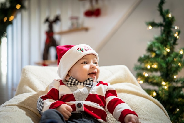 Menino sorridente em uma cadeira contra a decoração de Natal em casa