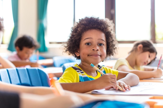 Foto menino sorridente estudando na sala de aula