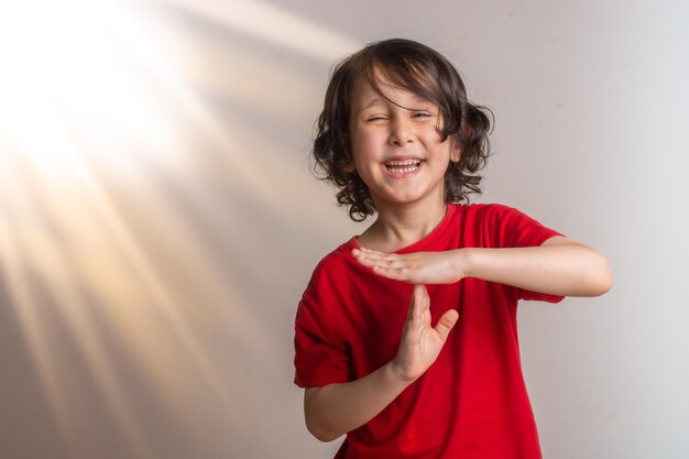Foto menino sorridente fazendo uma pausa ou um gesto com a mão no tempo de pausa