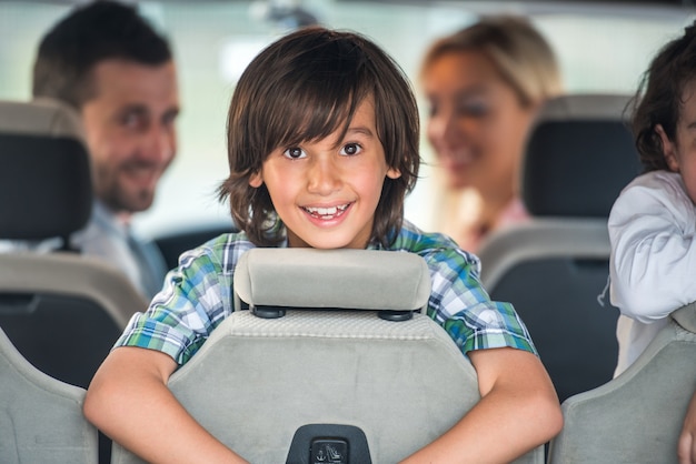 Menino sorridente no banco traseiro do carro