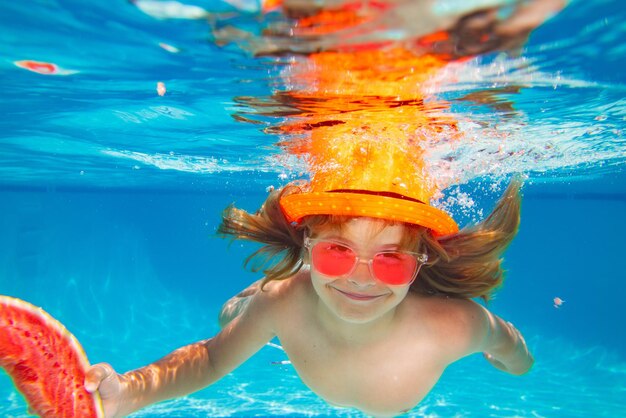 Menino subaquático de melancia de verão na piscina menino bonito nadando na piscina debaixo d'água