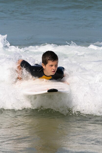 Menino surfista surfando ondas