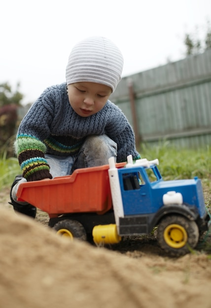 Foto menino, tocando, com, caminhão brinquedo, ao ar livre