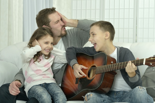 Menino tocando violão para sua família