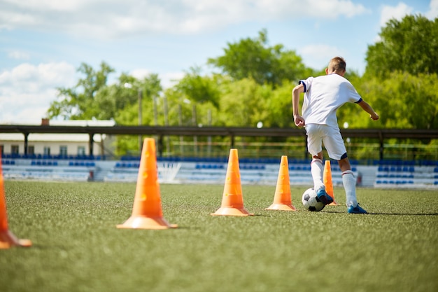 Menino treinando para jogo de futebol