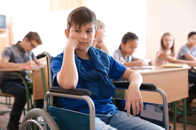 Menino triste em cadeira de rodas na escola