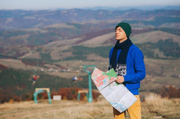 Menino turista em montanhas com mapa