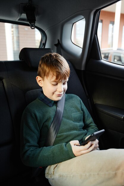 Menino usando smartphone no carro