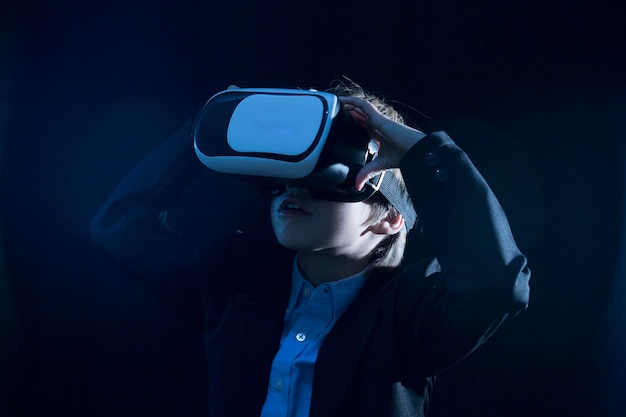 Menino vestindo um terno enquanto usa um simulador de realidade virtual