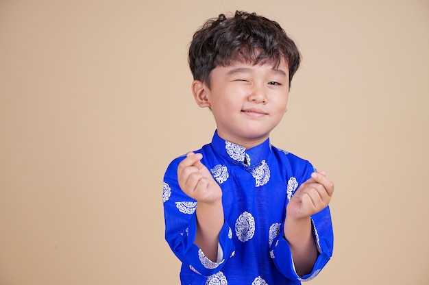 Foto menino vietnamita bonitinho em dai vestido sorrindo.