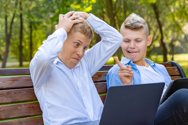 Meninos adolescentes no banco do parque se divertir e relaxar