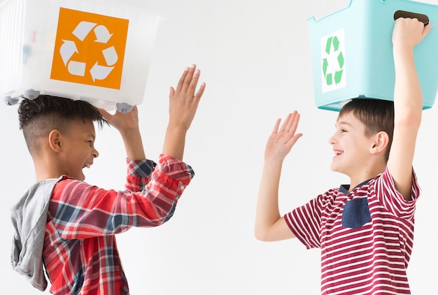 Meninos bonitos jovens felizes em reciclar juntos