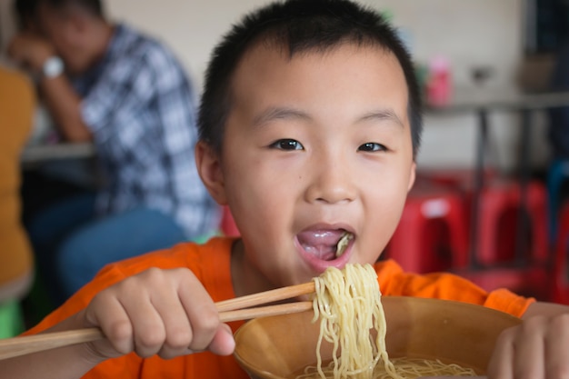 Meninos comendo macarrão de arroz delicioso