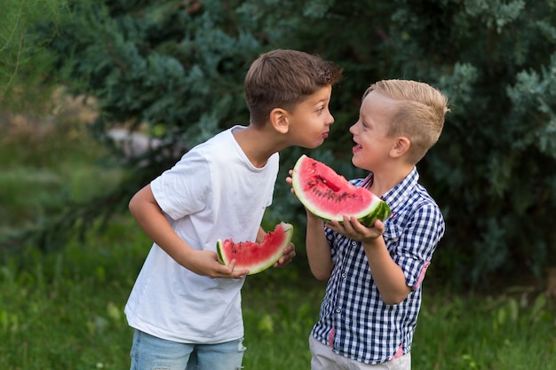 Meninos de crianças felizes comendo melancia no verão