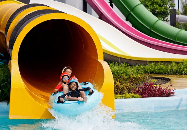 Meninos e mãe brincando no parque aquático i