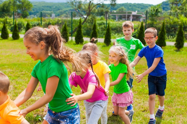 Jogos ativos para crianças em idade escolar e pré-escolares no ar. agachar  e pular. jogo ao ar livre para grupo de crianças.