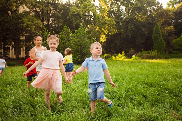 Meninos e meninas correndo no jardim e olhando atentamente para a distância