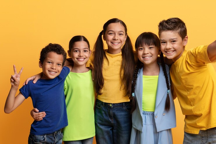 Foto meninos e meninas murraciais alegres e fofos tirando selfie em amarelo