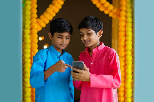 Meninos indianos usando smartphone e desfrutando do festival de diwali.