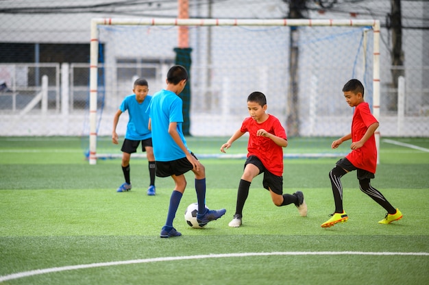 Meninos jogando futebol no campo de treino de futebol