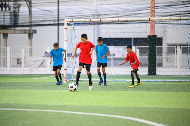 Meninos jogando futebol no campo de treino de futebol