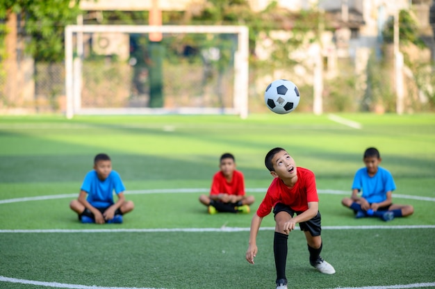 Meninos jogando futebol no campo de treino de futebol