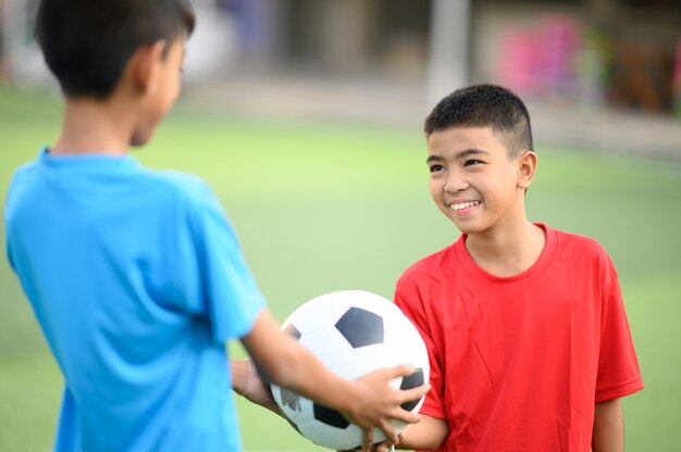 Meninos jogando futebol no campo de treino de futebol