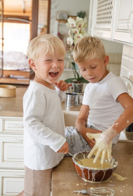 Meninos preparando torta caseira na cozinha. dois irmãos cooki