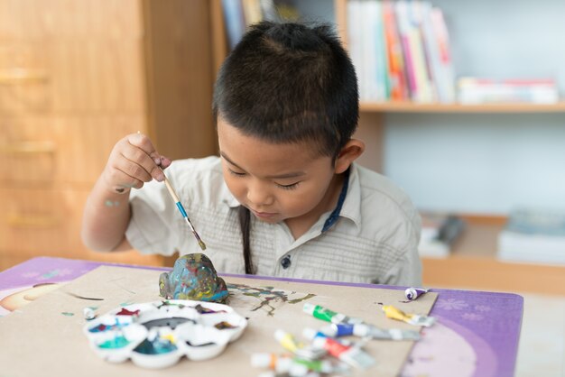 Meninos que são divertidos de pintar na casa.