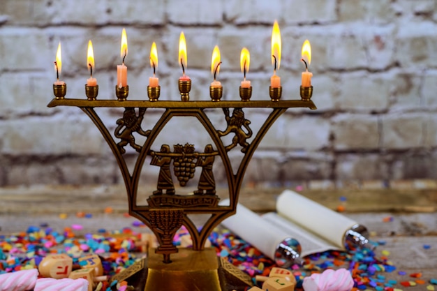 Menorá de bronze hanukkah com queima de velas na mesa de madeira velha frente vintage