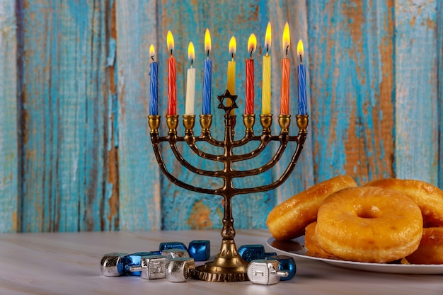 Menorá, rosquinhas e piões no conceito de hanukkah tabela.