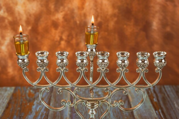 Menorah ein traditioneller jüdischer Feiertag, der die erste Kerze auf einem Chanukka einer brennenden Chanukka-Kerze Menorah anzündet