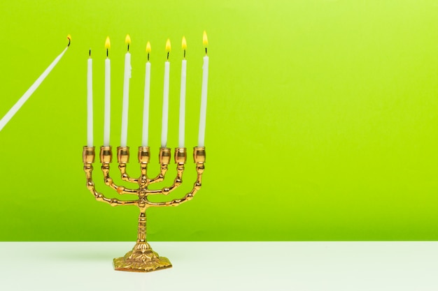 Menorah de Jánuca de bronce con velas encendidas