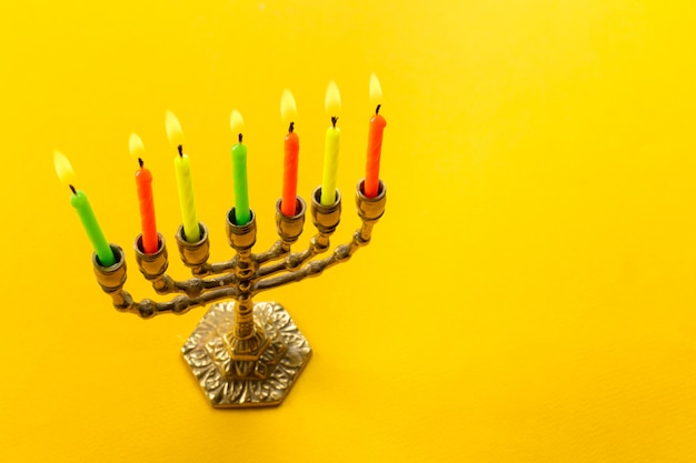 Menorah de Jánuca de bronce con velas encendidas