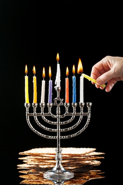 Menorah mit Kerzen für Chanukka auf schwarzem Hintergrund