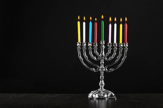 Menorah con velas para Hanukkah sobre fondo negro