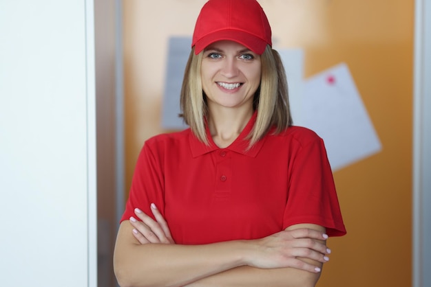 Mensageira loira feliz de camisa vermelha e boné de uniforme