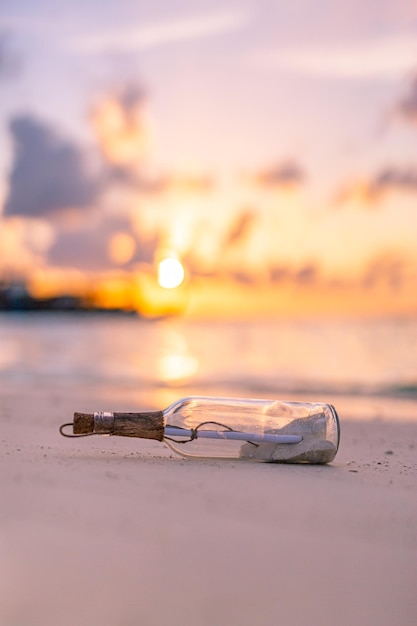 Mensagem na garrafa lavada em terra contra o pôr do sol. papel de parede de design de praia tropical