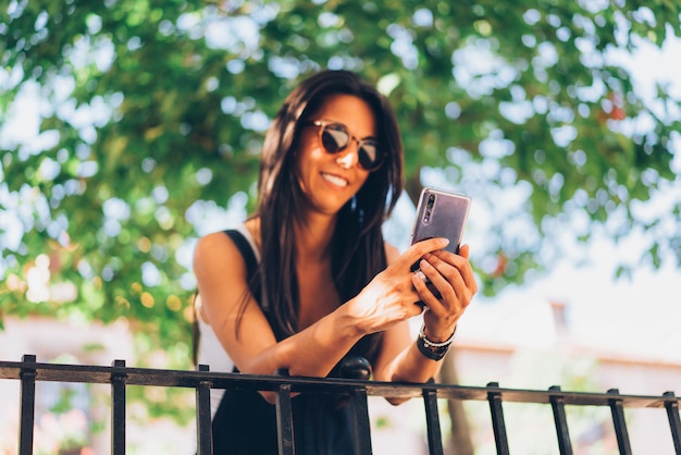 Mensagens de mulher bonita em um Smartphone e olhando para o celular