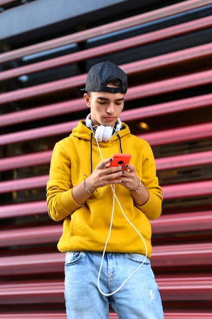 mensagens de texto de estudante masculino em smartphone na rua