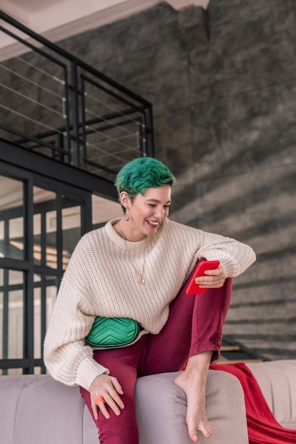 Mensaje de un amigo. Mensaje de lectura de mujer de moda de su mejor amiga en smartphone rojo