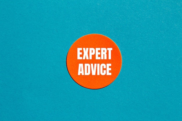 Mensaje de asesoramiento de expertos escrito en una pegatina naranja redonda con fondo azul Símbolo de asesoramiento conceptual de expertos Copiar espacio
