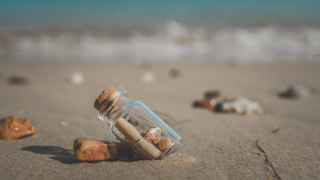 Mensaje en botella en la playa de arena