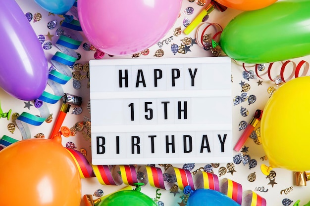 Mensaje de celebración de feliz cumpleaños número 15 en una caja de luz con globos y confeti