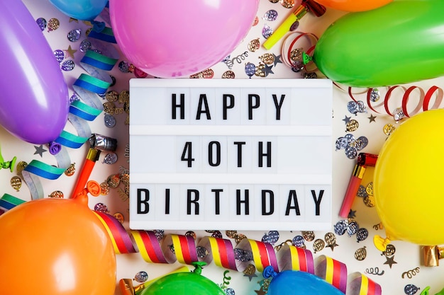 Mensaje de celebración de feliz cumpleaños número 40 en una caja de luz con globos y confeti