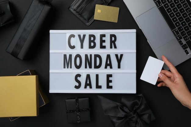 Foto mensaje de cyber monday en la mesa con regalos y computadora portátil.