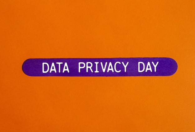 Mensaje del Día de la Privacidad de los Datos escrito en un palo de madera púrpura con fondo naranja Símbolo conceptual del día de la privacidad de los datos Copiar espacio